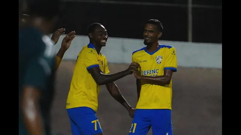 Cầu thủ của Defence Force vượt qua hậu vệ của Prisin Service trong trận đấu bóng đá